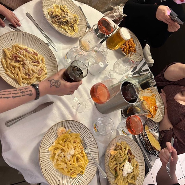 Overhead view of a group dining at a Bar Aldo’s restaurant table with pasta dishes and drinks in Alloa.